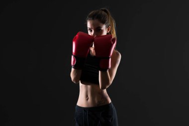 Boks eldivenleri koyu arka plan üzerinde kadınla spor