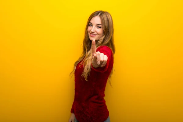 Chica Joven Sobre Fondo Amarillo Vibrante Mostrando Levantando Dedo —  Fotos de Stock