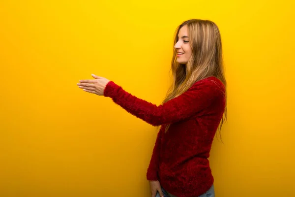 Junges Mädchen Auf Leuchtend Gelbem Hintergrund Beim Händeschütteln Nach Einem — Stockfoto