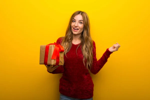 Chica Joven Sobre Fondo Amarillo Vibrante Sosteniendo Caja Regalo Las —  Fotos de Stock