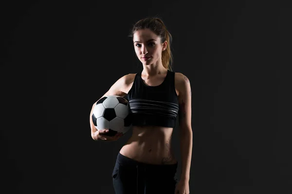 サッカー ボールを保持している暗い背景にスポーツの女性 — ストック写真