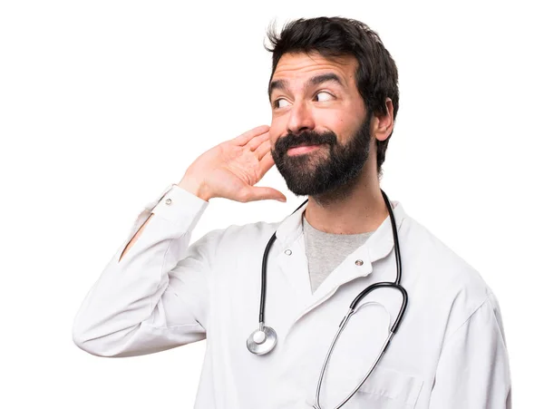 Joven Médico Escuchando Algo Sobre Fondo Blanco — Foto de Stock