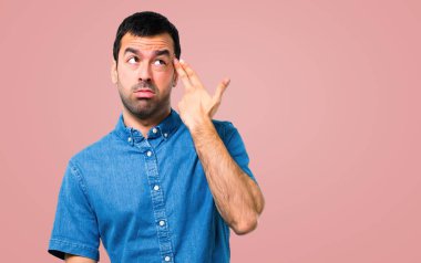 Mavi gömlek yapma intihar hareketi üzerinde pembe bir arka plan ile yakışıklı adam