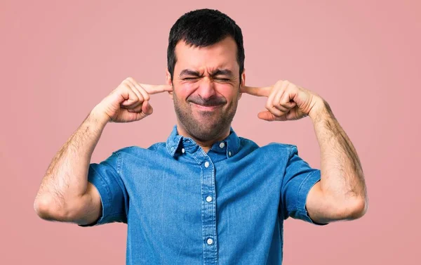 Handsome Man Blue Shirt Covering Both Ears Hands Pink Background — Stock Photo, Image