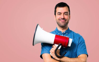 Mavi gömlek pembe bir megafon holding ile yakışıklı adam