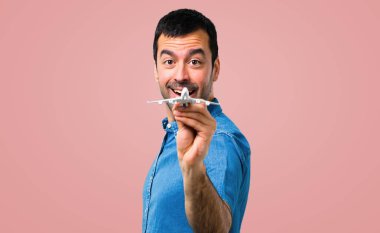 Mavi gömlek pembe bir oyuncak uçak holding ile yakışıklı adam