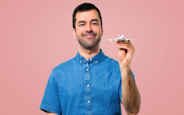 Mavi gömlek pembe bir oyuncak uçak holding ile yakışıklı adam