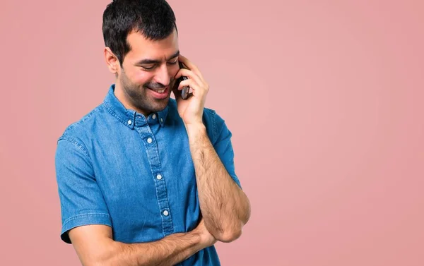 Pohledný Muž Modrou Košili Mluví Růžovém Pozadí Mobil — Stock fotografie