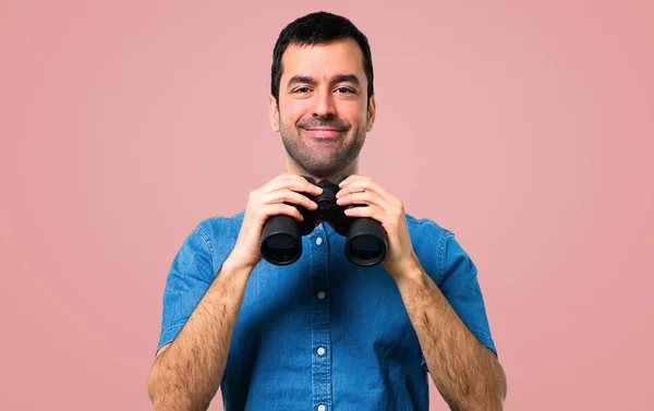 Pohledný Muž Modrou Košili Dalekohledem Růžovém Pozadí — Stock fotografie