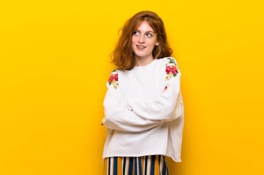 Sarı duvar gülümseyen süre ararken genç Kızıl saçlı kadın