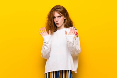 Sarı duvar yapma dur hareketi her iki el ile genç Kızıl saçlı kadın