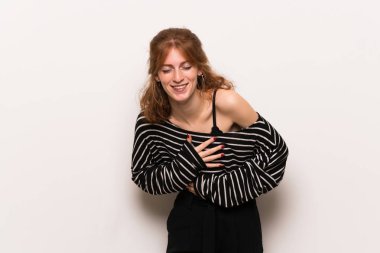 Beyaz duvar çok giyerken gülümseyen genç Kızıl saçlı kadın göğüs üzerinde eller