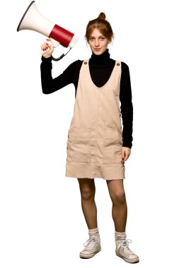 Tam uzunlukta fotoğrafını bir megafon izole beyaz arka plan üzerinde tutan bir genç Kızıl saçlı kadın