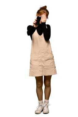 Bir genç Kızıl saçlı kadın tam uzunlukta bir kadeh kırık bir telefon ile izole beyaz arka plan üzerinde üzgün.