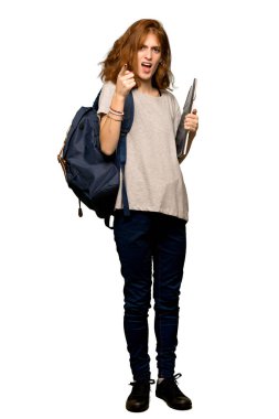 Kötü bir durum ve önüne izole beyaz arka plan üzerinde göstererek sinirli bir genç redhead öğrenci tam uzunlukta bir kadeh