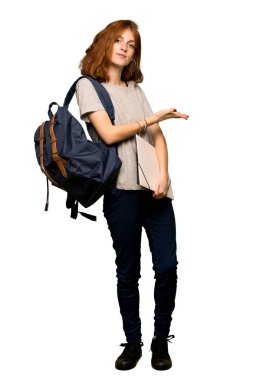 Bir fikir görünümlü doğru izole beyaz arka plan üzerinde gülümseyen iken sunan bir genç redhead öğrenci tam uzunlukta bir kadeh