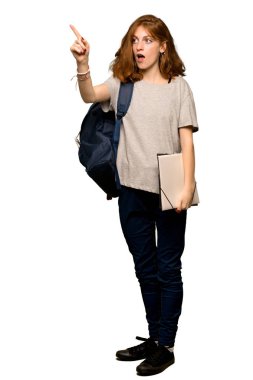 Uzak izole beyaz arka plan üzerinde işaret eden bir genç redhead öğrenci tam uzunlukta bir kadeh