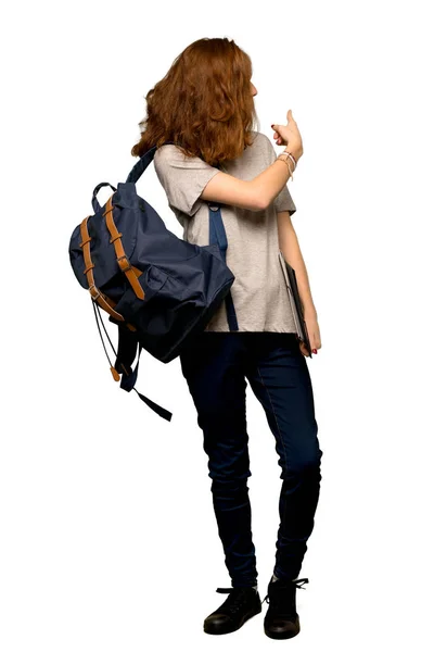 一个年轻的红头发的学生用食指指着孤立的白色背景的全长照片 — 图库照片
