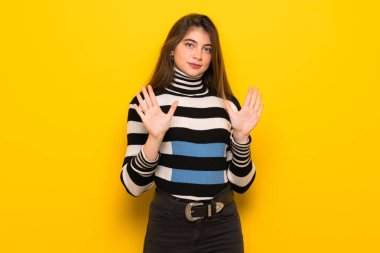Sarı duvar yapma dur hareketi her iki el ile genç kadın