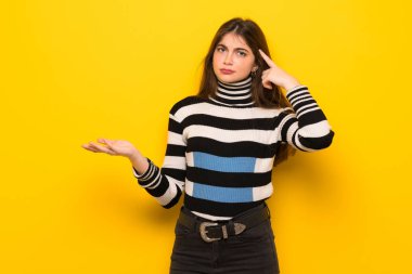 Sarı duvar parmak kafasına koyarak delilik jest yapma genç kadın