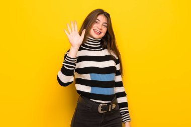 Beş parmak ile sayma sarı duvarın üzerinden genç kadın