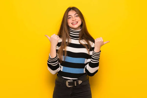 Young Woman Yellow Wall Giving Thumbs Gesture Both Hands Smiling — Stock Photo, Image