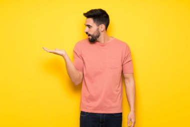 Yakışıklı adam boşaltmak hayali avuç içinde tutan sarı duvarın üzerinden bir reklam eklemek için