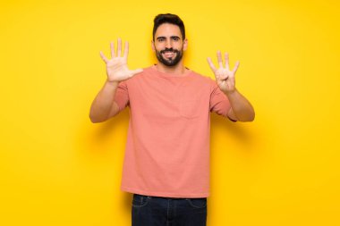 Dokuz parmaklı sayma sarı duvarın üzerinden yakışıklı adam