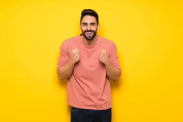 Hombre Guapo Sobre Pared Amarilla Celebrando Una Victoria Posición Ganadora — Foto de Stock