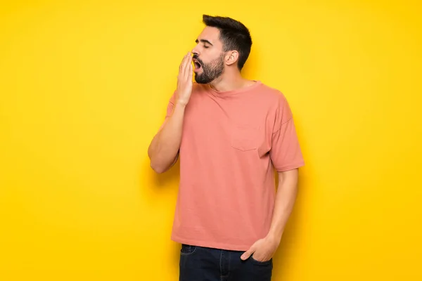 Hombre Guapo Sobre Pared Amarilla Bostezando Cubriendo Boca Abierta Con — Foto de Stock