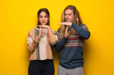 Hippi Çift sarı arka plan yapma dur jestle bir hareket durdurmak için elini üzerinde