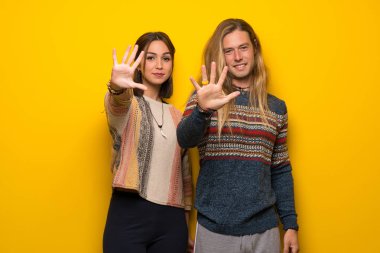 Hippi Çift sarı arka plan beş parmak ile sayma üzerinde