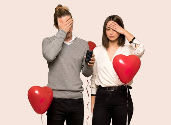 Couple in valentine day with troubled holding broken smartphone over isolated background