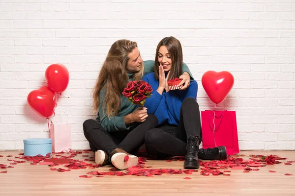 一对夫妇在情人节与鲜花和礼物 — 图库照片