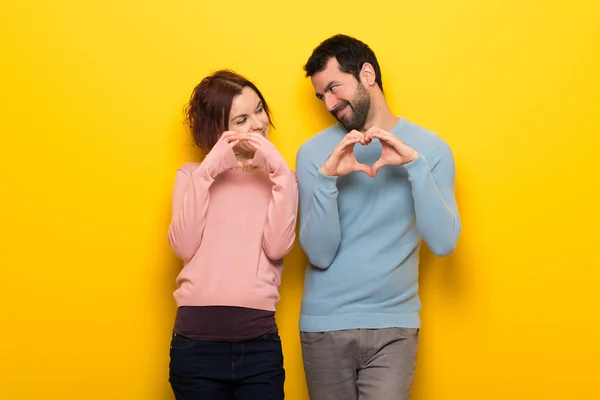 バレンタインの手によってハートのシンボルを作る日のカップル — ストック写真