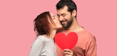 İki kalp simgesi tutan ve izole pembe arka plan üzerinde öpüşme valentines gün içinde
