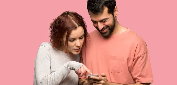 Coppia San Valentino Invio Messaggio Con Cellulare Sfondo Rosa Isolato — Foto Stock
