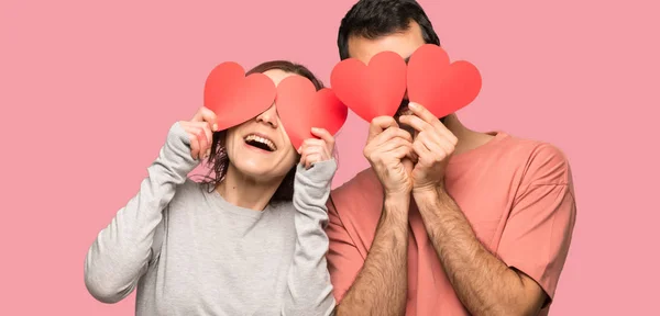 Pár Valentine Den Drží Symbol Srdce Nad Izolované Růžové Pozadí — Stock fotografie