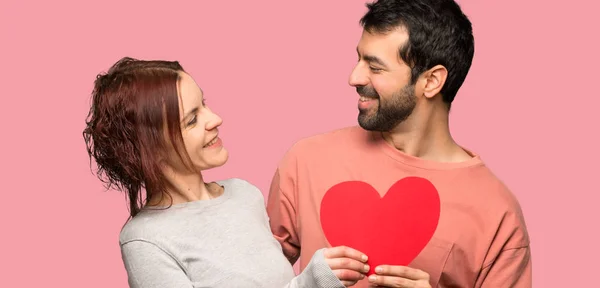 Paar Valentinstag Mit Einem Herzsymbol Auf Isoliertem Rosa Hintergrund — Stockfoto