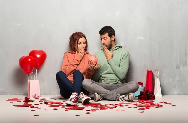 一对夫妇在情人节惊讶 而抱着一个存钱罐 — 图库照片