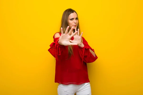 Junges Mädchen Mit Rotem Kleid Über Gelber Wand Ist Etwas — Stockfoto