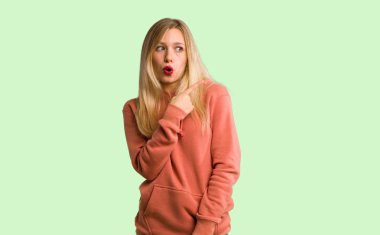 Şaşırttı ve yan üzerinde yeşil arka planı gösteren genç kız