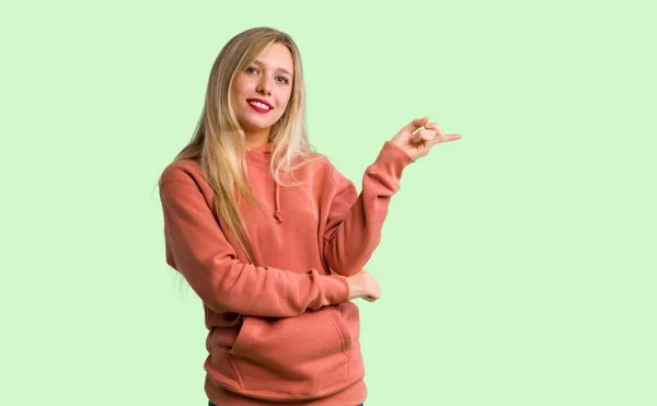 Молода Дівчина Спрямовує Палець Бічне Положення Зеленому Тлі — стокове фото