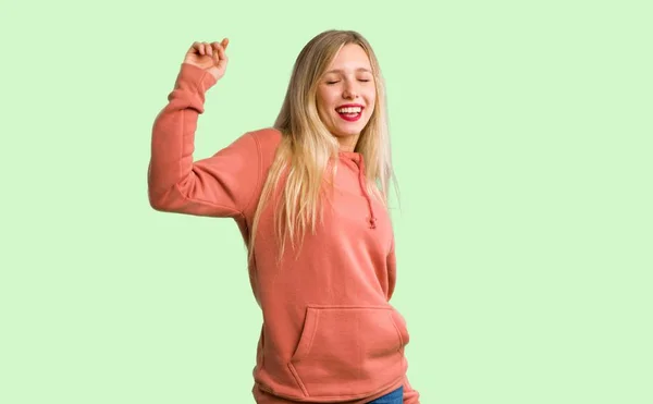 Jovem Gosta Dançar Enquanto Ouve Música Uma Festa Fundo Verde — Fotografia de Stock