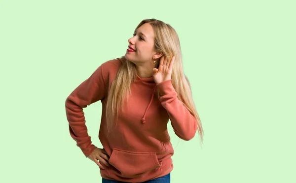 Menina Ouvindo Algo Colocando Mão Orelha Fundo Verde — Fotografia de Stock