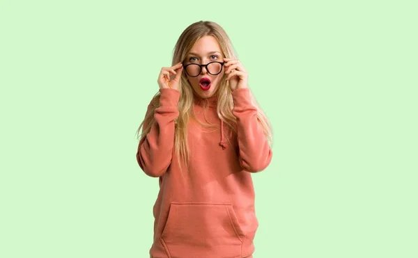 Chica Joven Con Gafas Sorprendida Sobre Fondo Verde —  Fotos de Stock