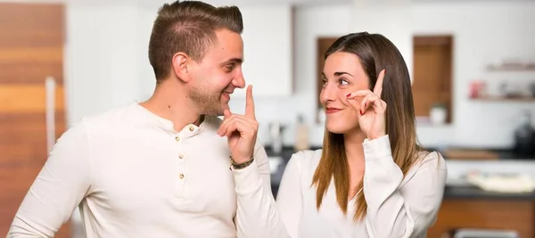 バレンタインの日のつもりでカップルが家で指を持ち上げながらソリューションを実現します — ストック写真