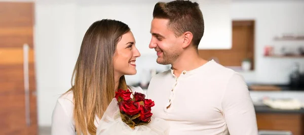 一对夫妇在情人节与鲜花在房子里 — 图库照片