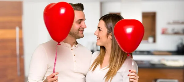 一对在情人节与气球与心脏形状在房子 — 图库照片