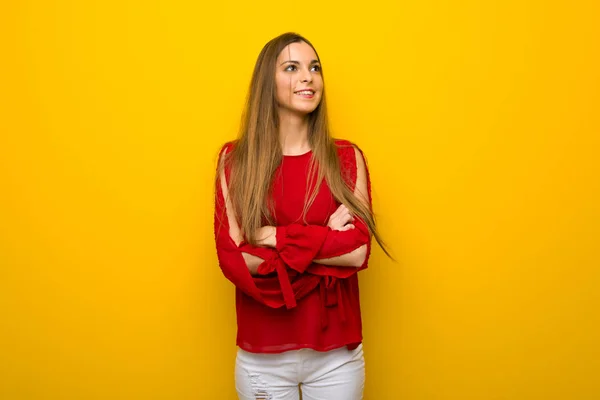 Junges Mädchen Mit Rotem Kleid Über Gelber Wand Blickt Lächelnd — Stockfoto